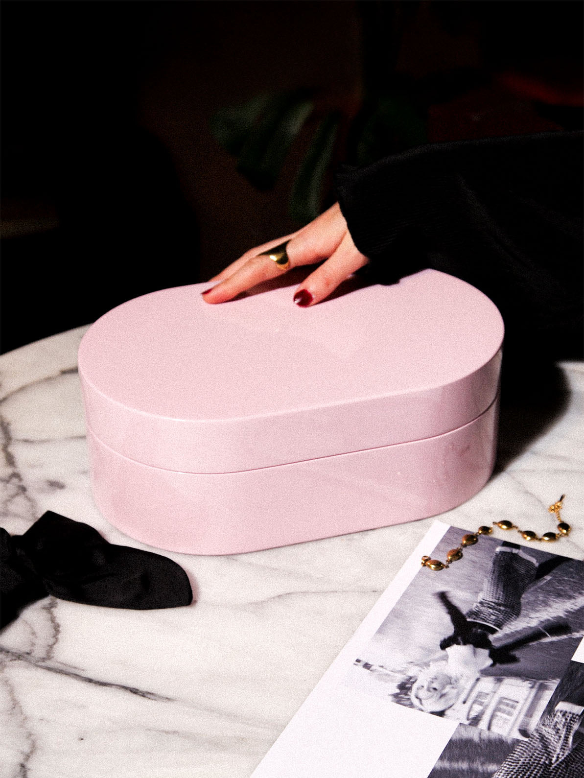 Rosa smyckeskrin från misou med en hand på